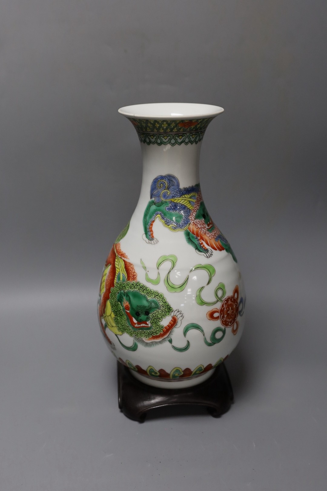 A Chinese famille verte pear shaped ‘Buddhist lion’ vase, on stand, 32 cms high not including stand.